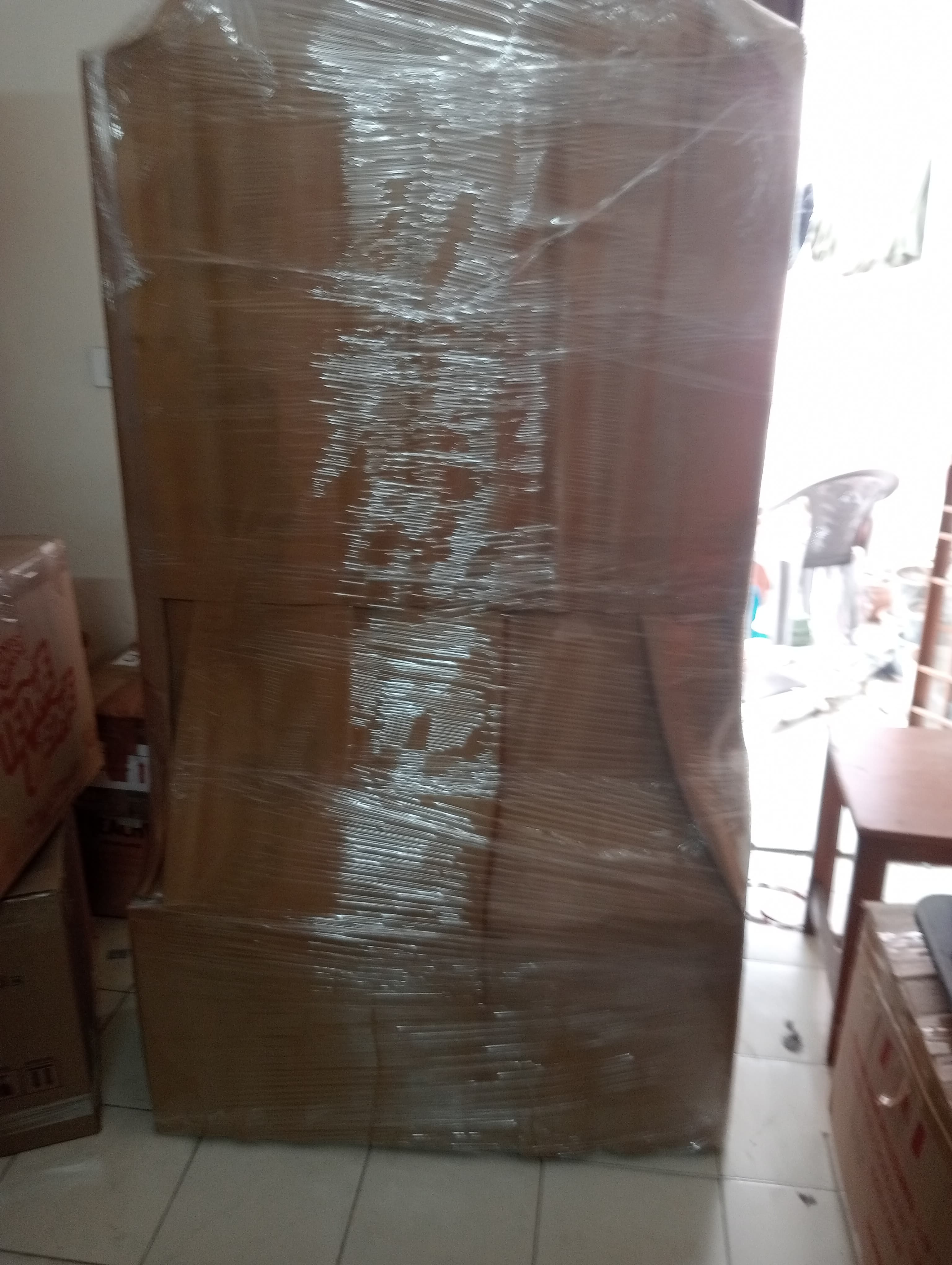 Movers wrapping a mirror with protective film