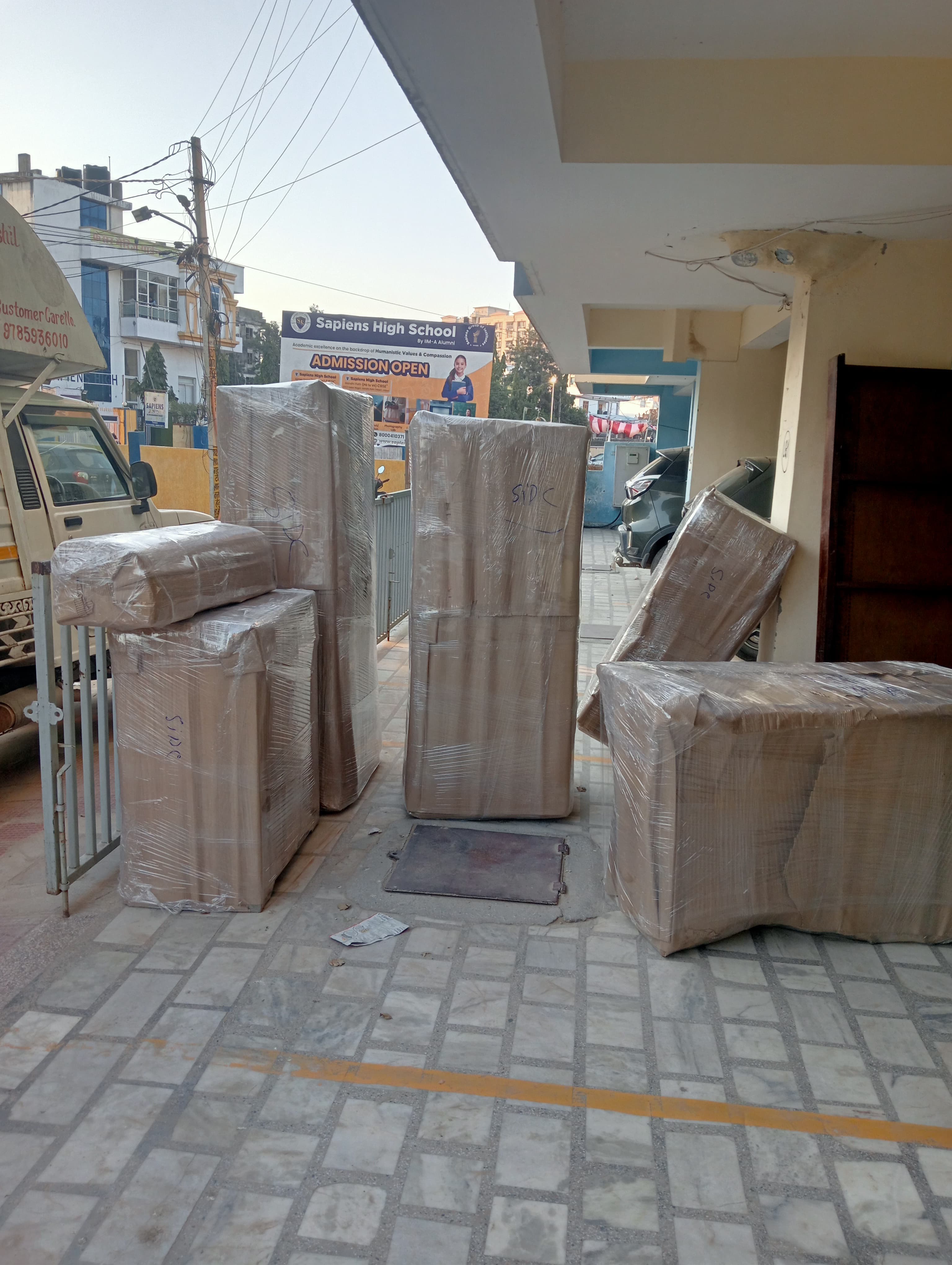 Movers wrapping a sofa with protective film